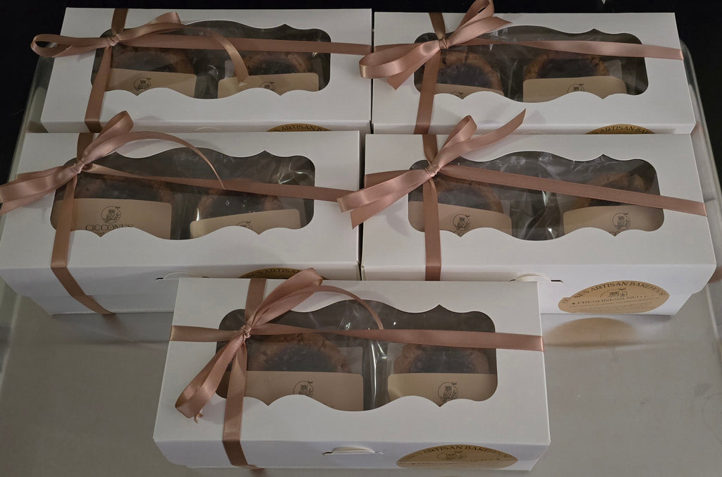 White boxes with windowed panels and brown ribbons, containing cookies.