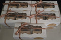 White boxes with windowed panels and brown ribbons, containing cookies.