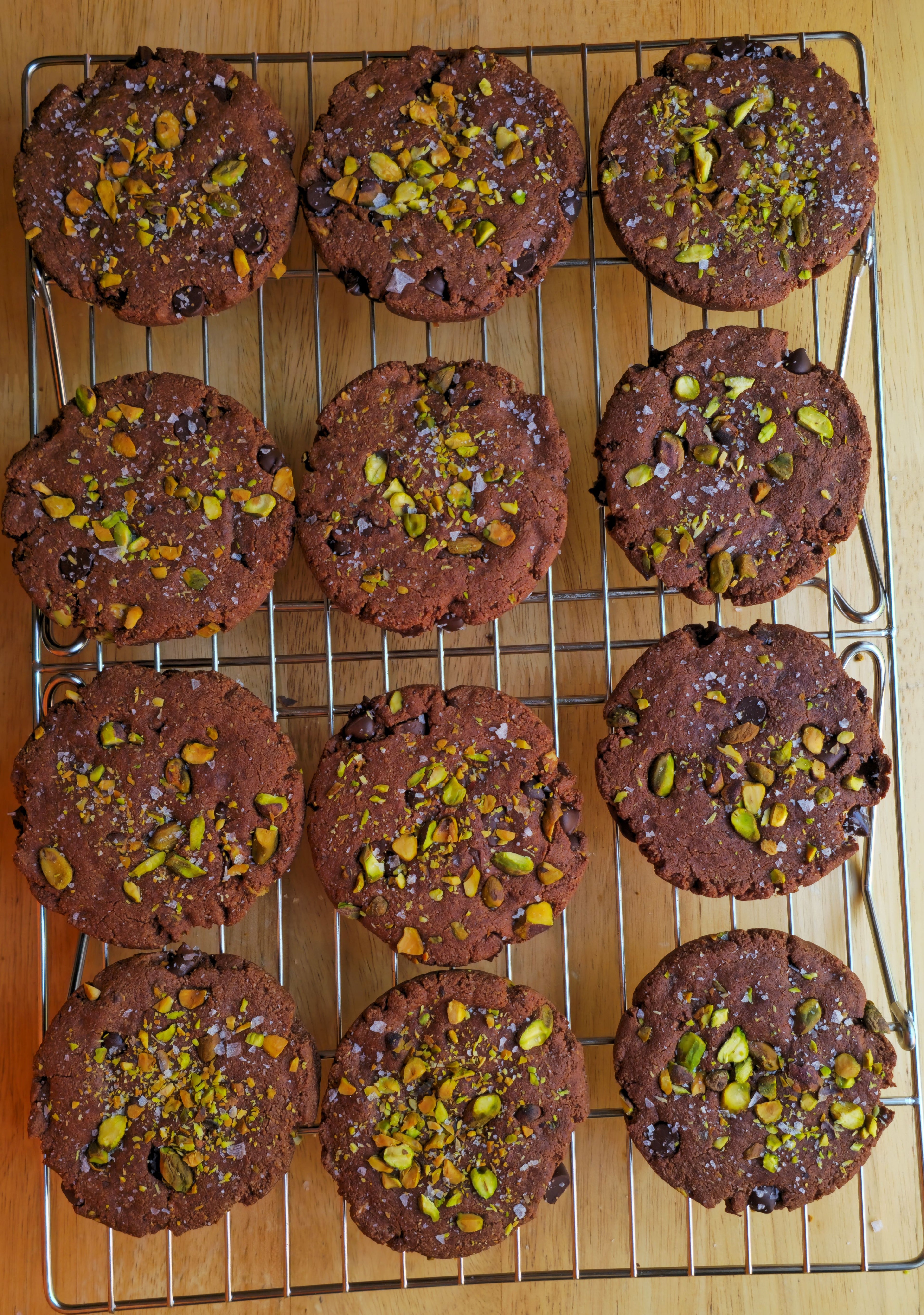 Chocolate cookies with pistachios on a cooling rack