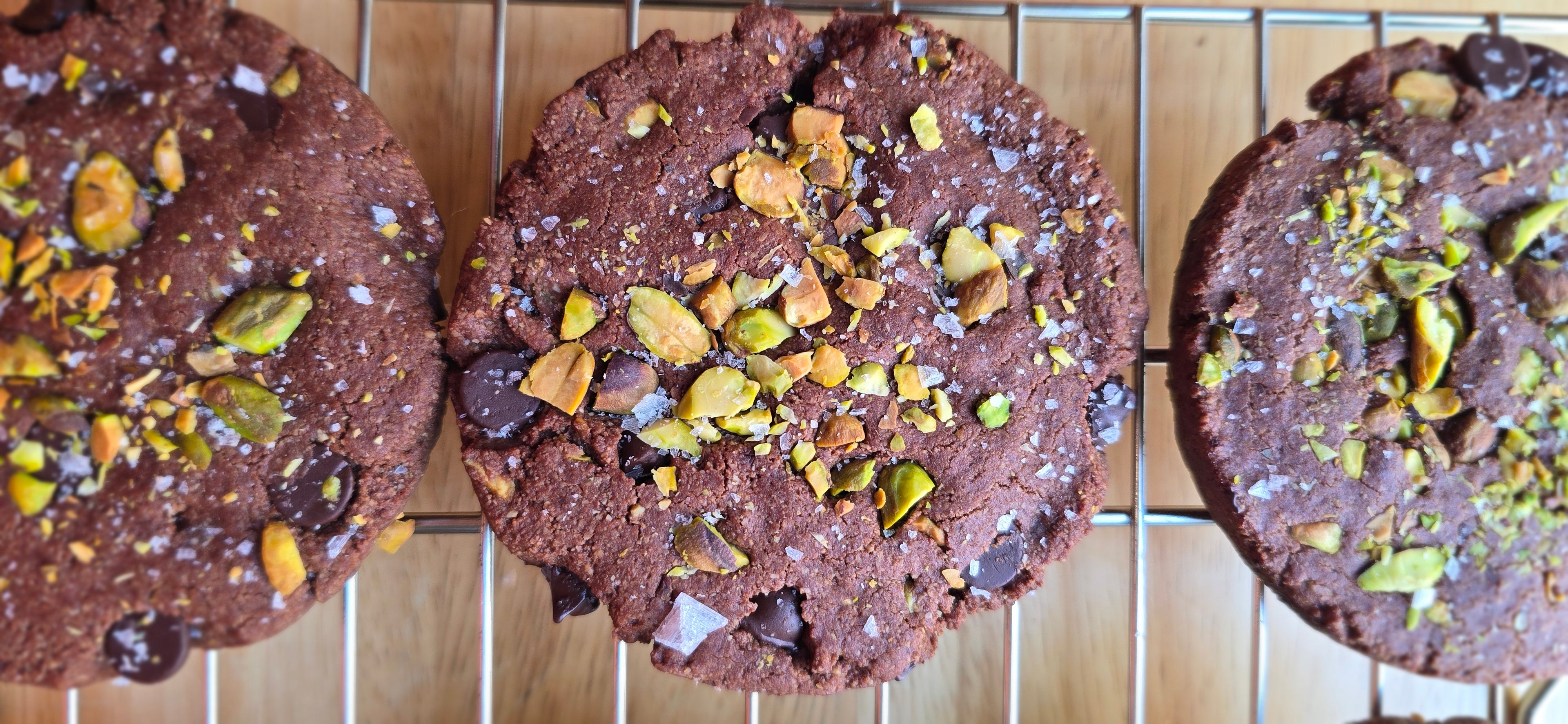 chocolate cookies with pistachios on a cooling rack