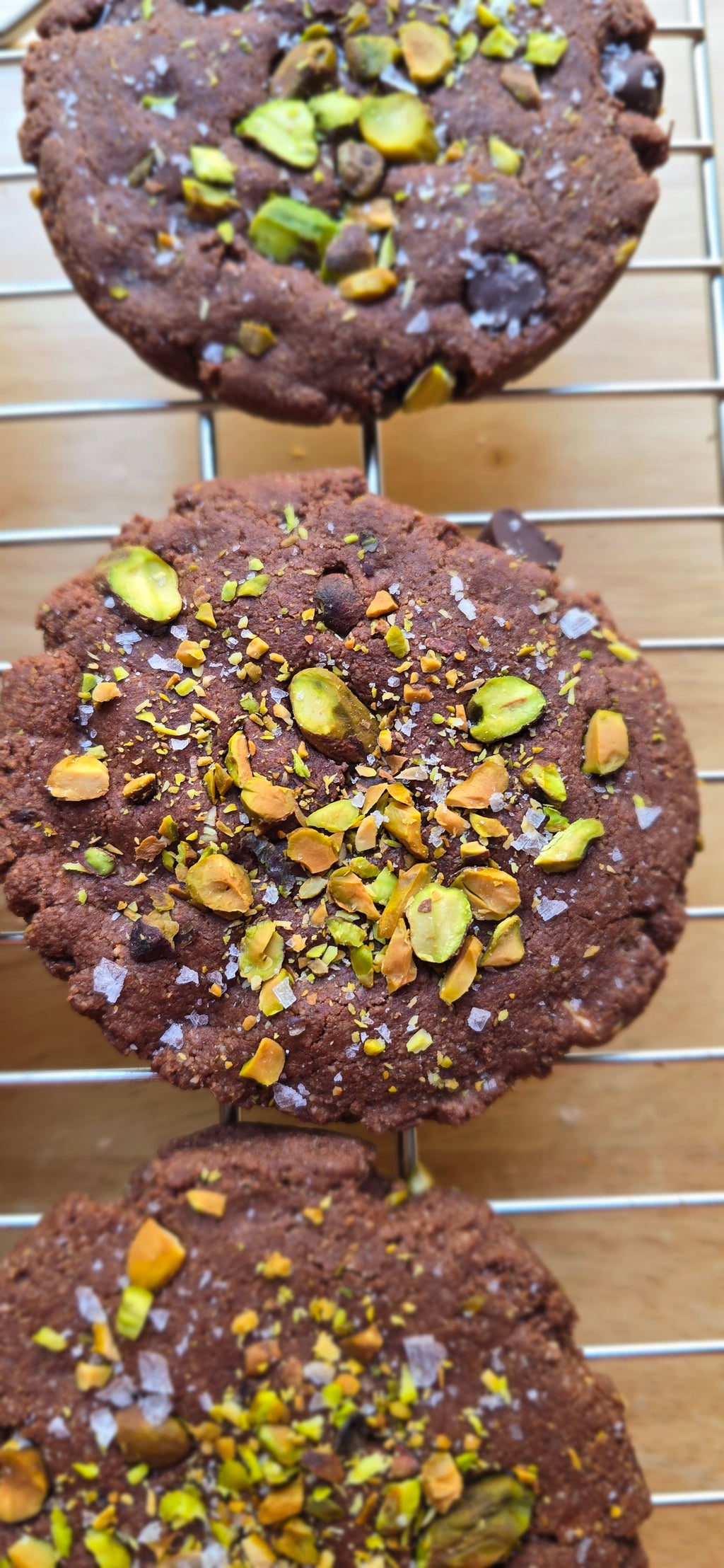 Chocolate cookies with pistachios on a cooling rack