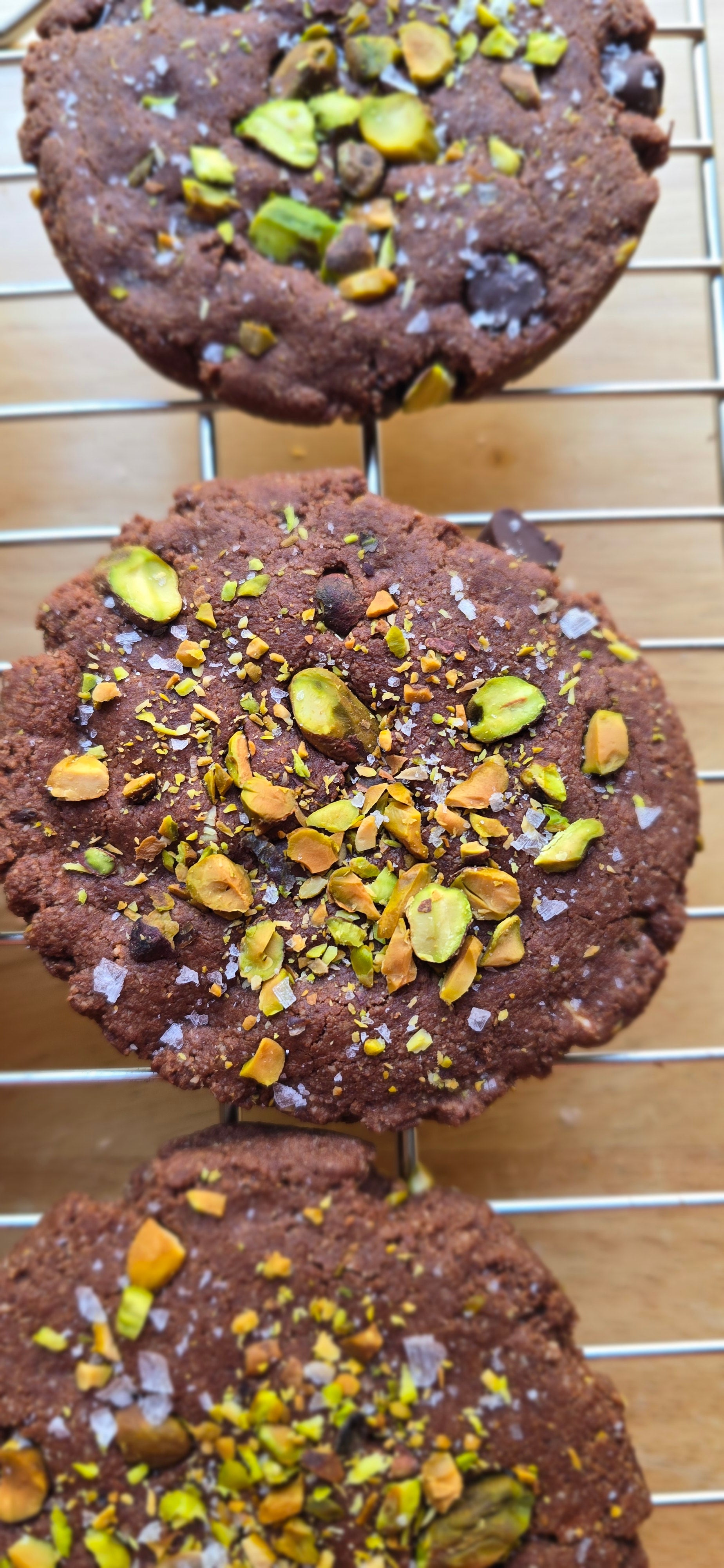 Chocolate cookies with pistachios on a cooling rack