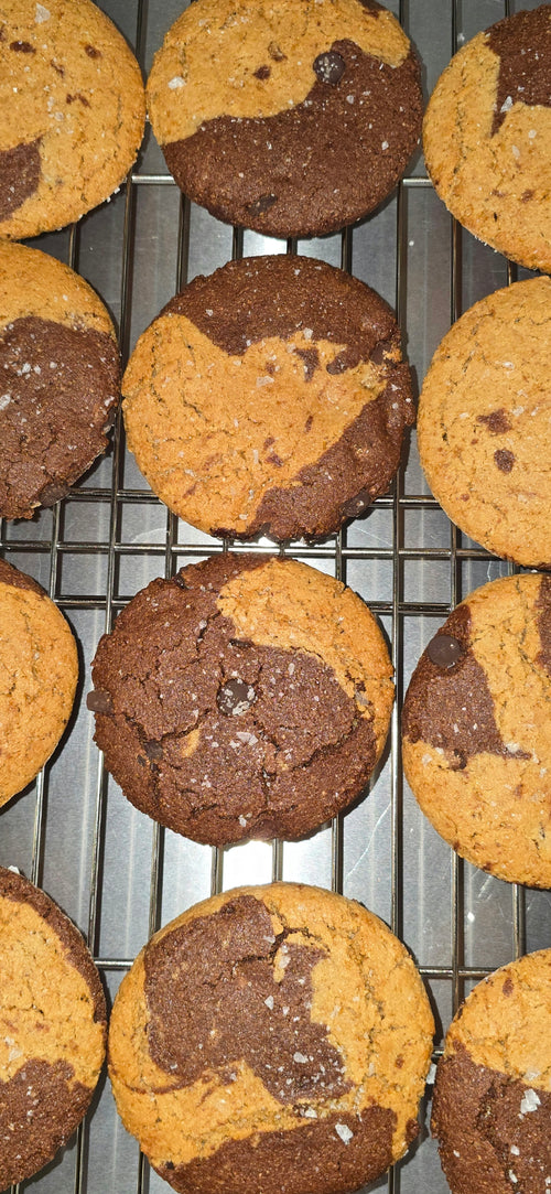 Baked cookies with a marbled chocolate and peanut butter pattern on a cooling rack.